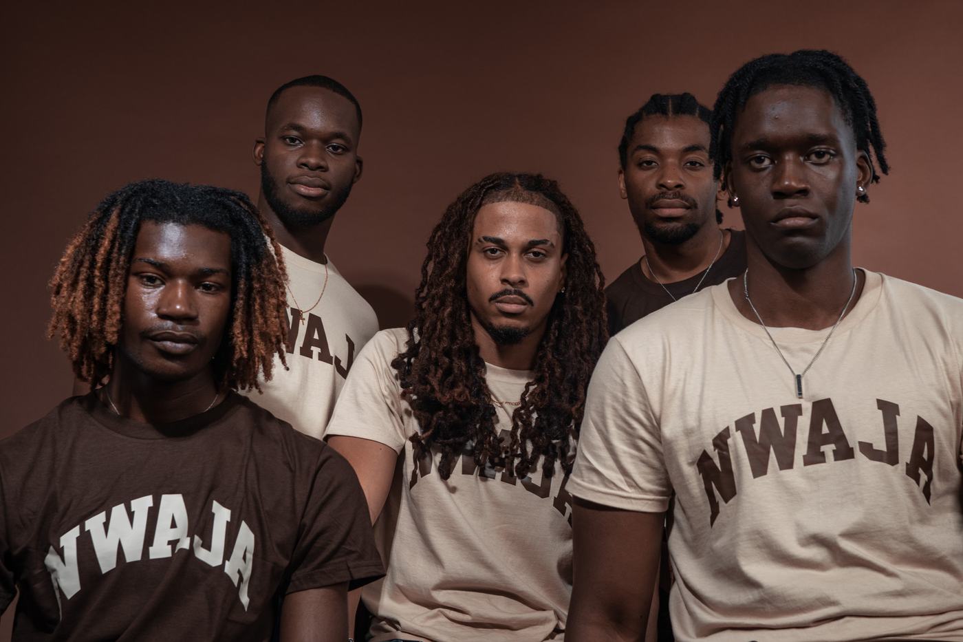 Cinq membres du collectif NWAJA en t-shirts Espresso et Sable